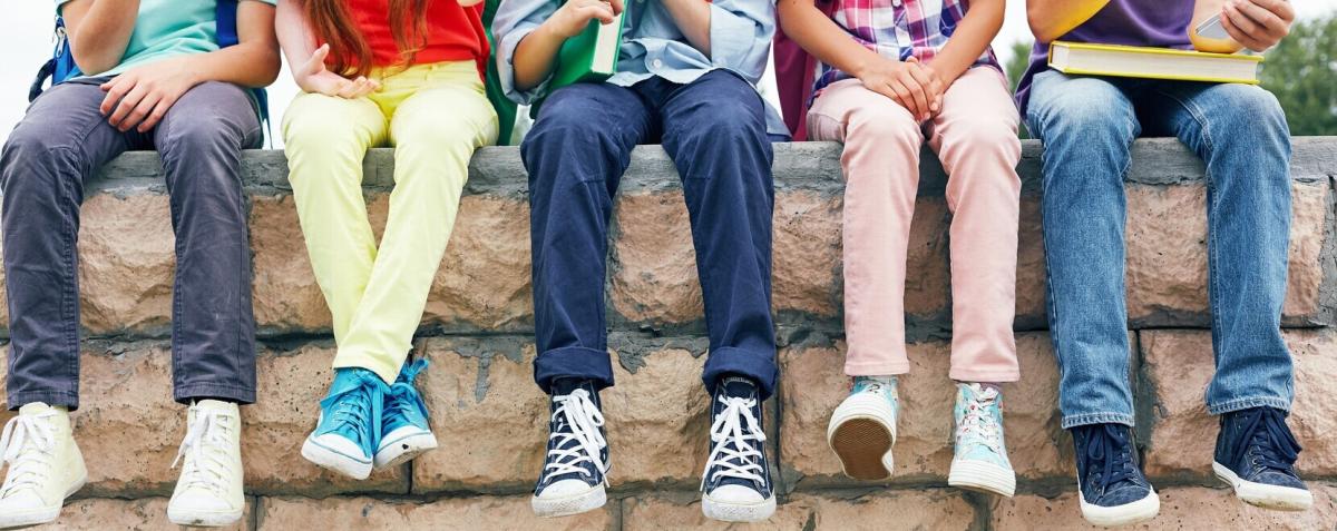 photos où l&#039;on voit les jambes de 5 enfants assis sur un mur